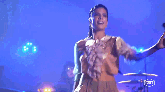 a woman is singing into a microphone with a cmt logo in the corner