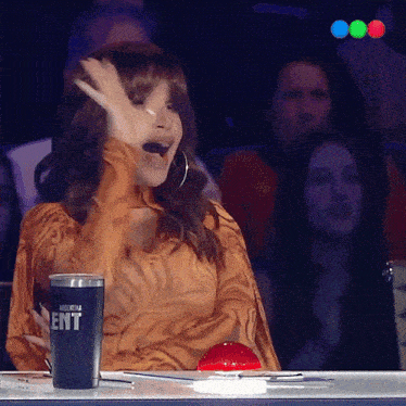 a woman sitting at a table with a cup that says ent on it