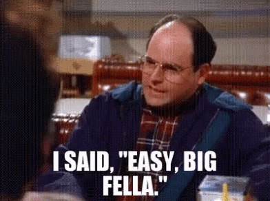 a man with glasses is sitting at a table and says i said easy big fella