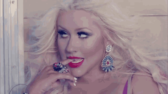a woman with blonde hair and red lips is wearing earrings