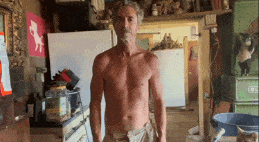 a man without a shirt is standing in front of a green box that says ' ol ' on it