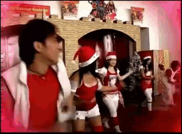 a group of people are dancing in front of a fireplace with a sign that says ' christmas festival ' on it