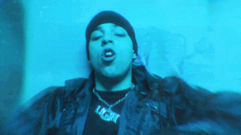 a man wearing a black jacket and a necklace with the word light on it