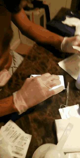 a person wearing gloves is looking at a cell phone screen