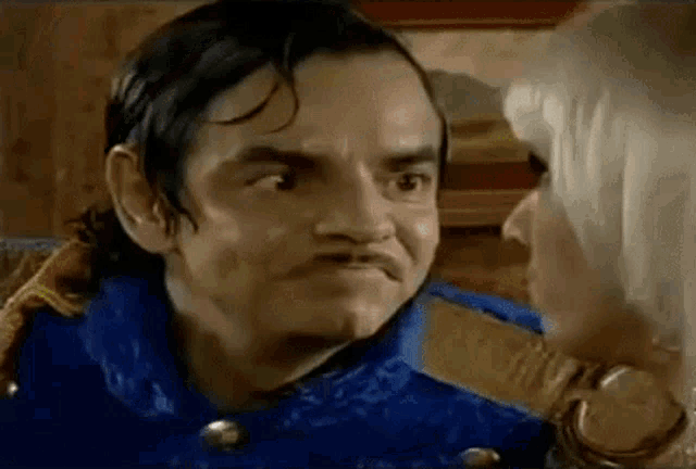 a man and a woman are looking at each other in a room .