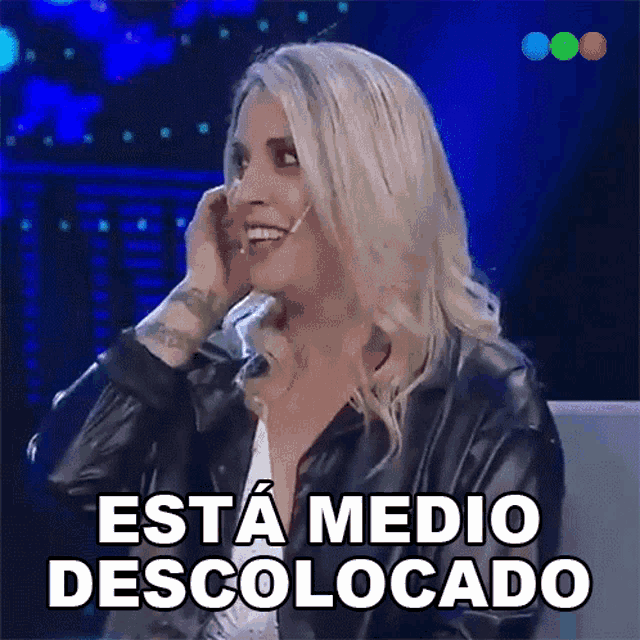 a woman is smiling and talking on a cell phone with the words esta medio descolocado above her