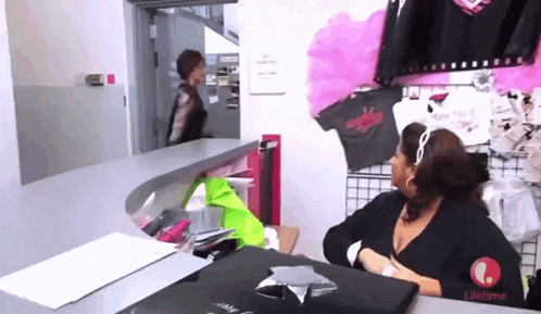 a woman is sitting at a desk with a lifetime logo on it