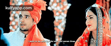 a man and a woman are standing next to each other and the man is wearing an orange turban