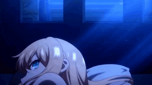 a girl with long blonde hair and blue eyes is laying down in a dark room .