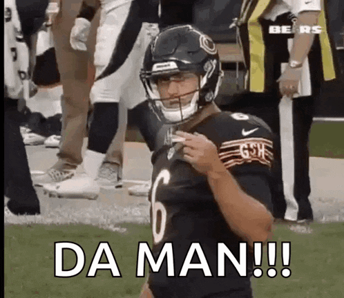 a football player wearing a helmet is standing on a field with the words `` da man ! ''