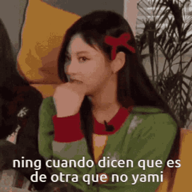a girl with long hair is sitting on a couch with her hand on her chin and says ning cuando dicen que es