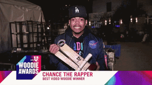 a man wearing a la hat is holding a wooden crate