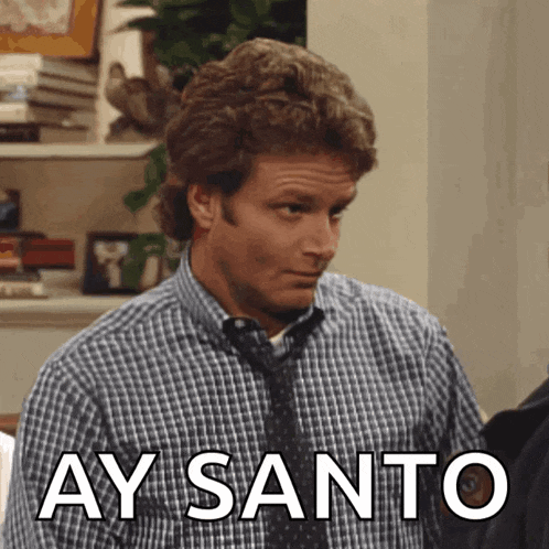 a man in a plaid shirt and tie has ay santo written on his chest