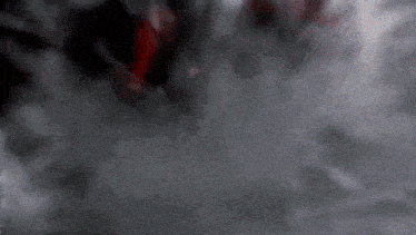 a blurry picture of a person in a dark room with smoke coming out of their mouth .