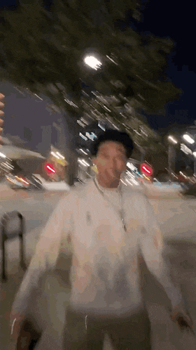 a blurry picture of a man walking down a street at night .