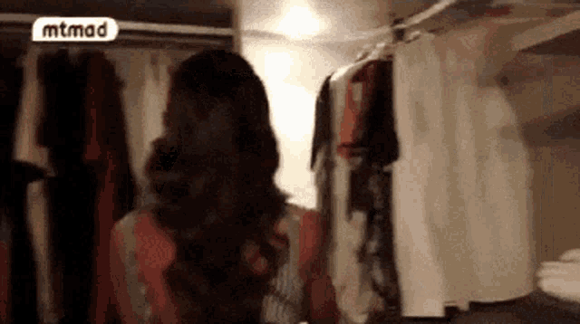 a woman in a closet with a mtmad logo on the bottom