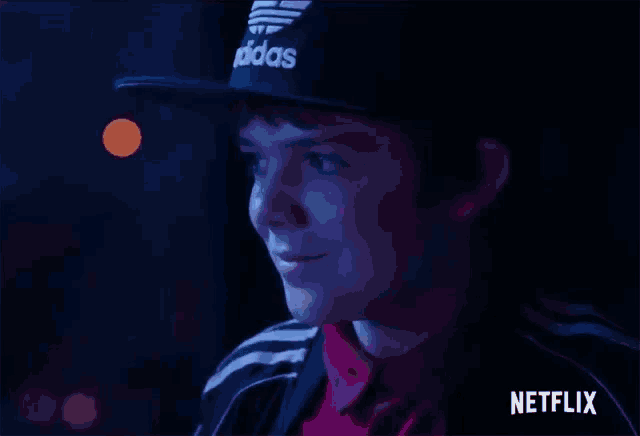 a young man wearing an adidas hat and a netflix logo