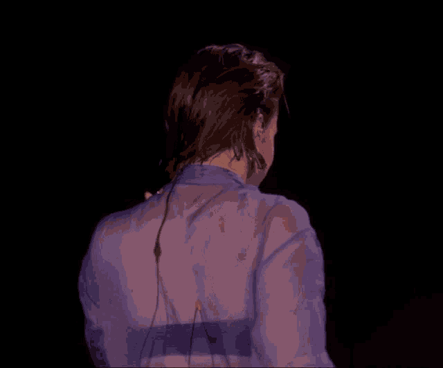 a woman 's back is shown in a purple top