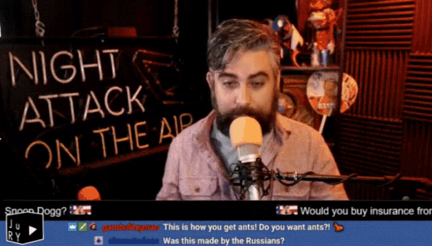 a man speaking into a microphone in front of a sign that reads night attack on the air