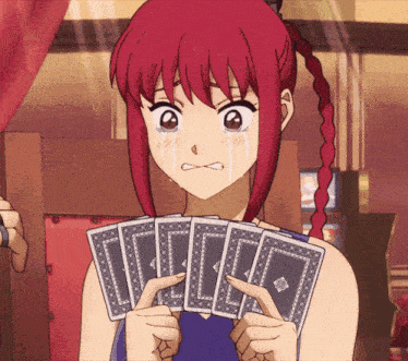 a girl with red hair is holding a stack of playing cards