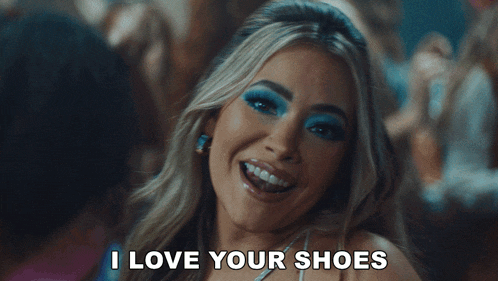 a woman with blue eye shadow is smiling and says i love your shoes