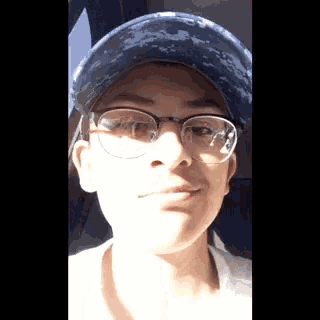 a person wearing glasses and a hat is making a funny face .
