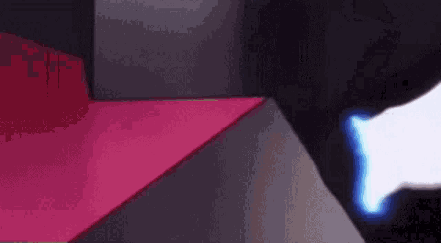 a person is standing in a dark room with a red carpet and a blue light coming out of the corner .