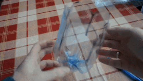 a person holding a piece of plastic on a table