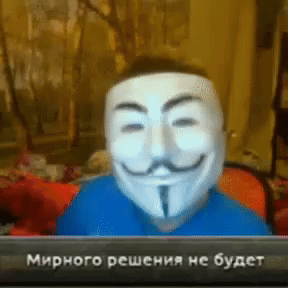 a man wearing a mask with a mustache is sitting in front of a computer screen that says мирного решения не будет