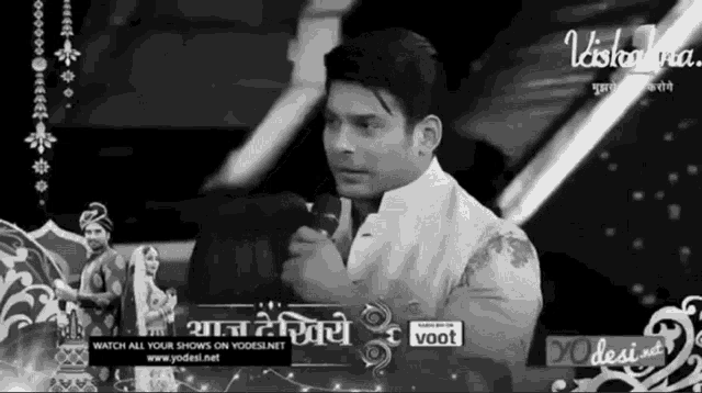 a black and white photo of a man speaking into a microphone on a yodesi.net advertisement