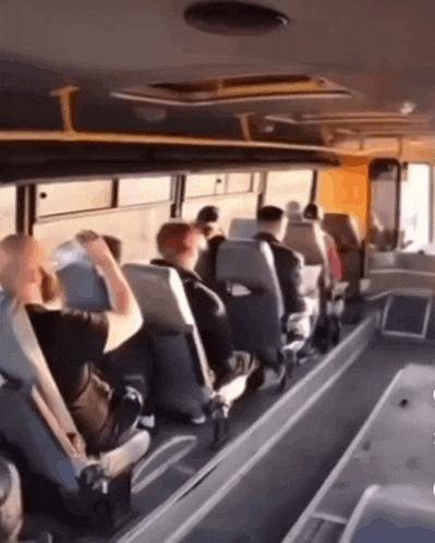a group of people are sitting on a bus looking at something