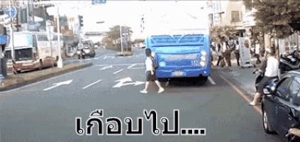 a blue bus is stopped on the side of the road in a city