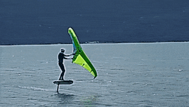 a man is flying a kite over a body of water