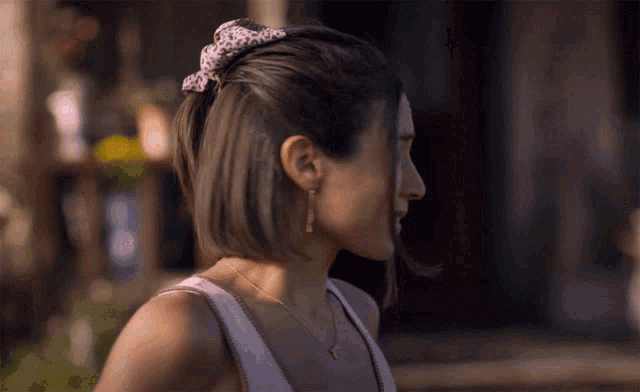 a woman in a white tank top has a leopard print headband on her head