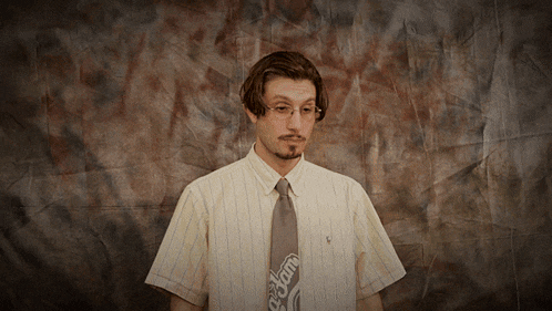 a man wearing a striped shirt and a tie that says cream