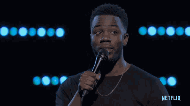 a man holding a microphone with netflix written on the bottom