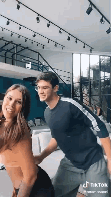 a man and a woman are dancing together in a living room in a house .