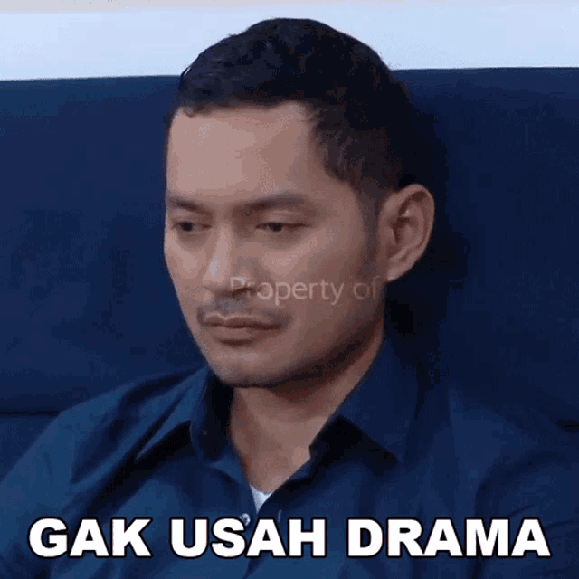 a man sitting on a couch with a caption that says " gak usaha drama "