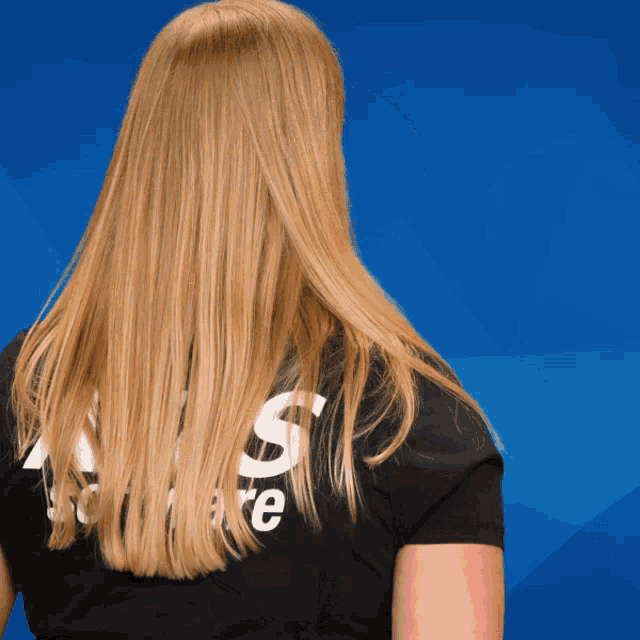 a woman with long blonde hair is wearing a black shirt that says associate on it
