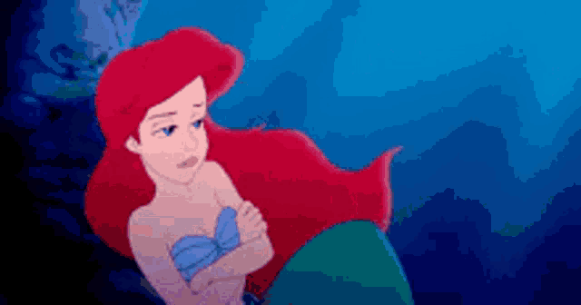 ariel from the little mermaid is swimming in the ocean .
