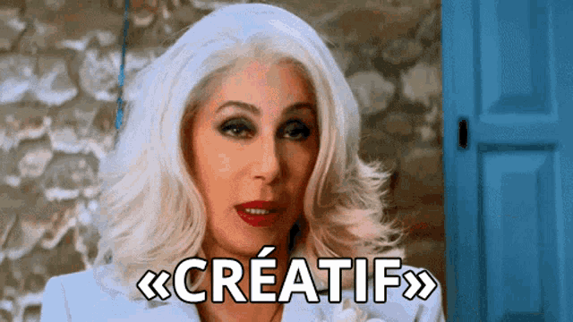 a woman with white hair and red lips says creativ in french