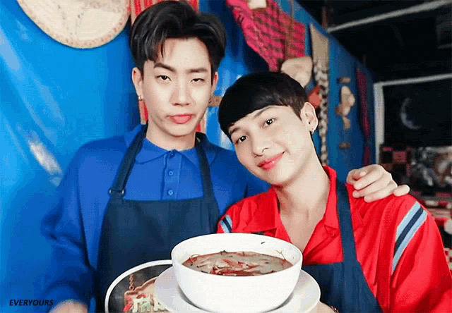 two men are posing for a picture with a bowl of soup in the foreground