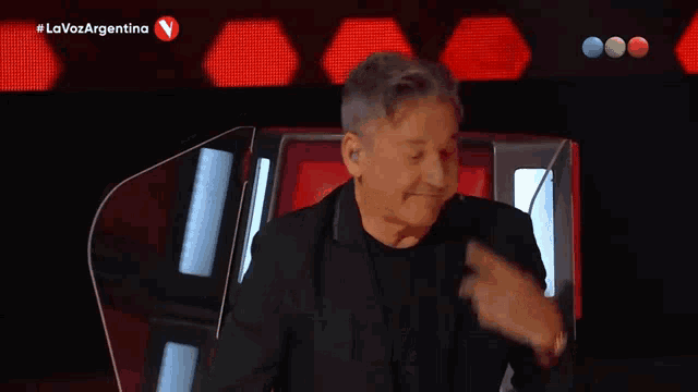 a man sitting in front of a microphone with #lavozargentina written on the bottom