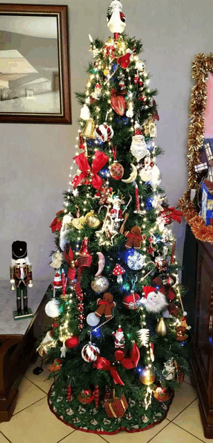 a decorated christmas tree with a nutcracker on a table in front of it