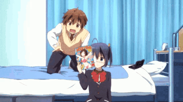 a boy and a girl are sitting on a bed looking at a magazine