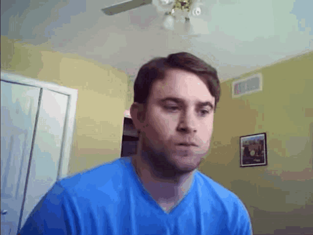 a man in a blue shirt looks at the camera