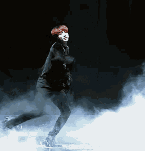 a man with red hair is dancing on a stage with the number 03 on the bottom right