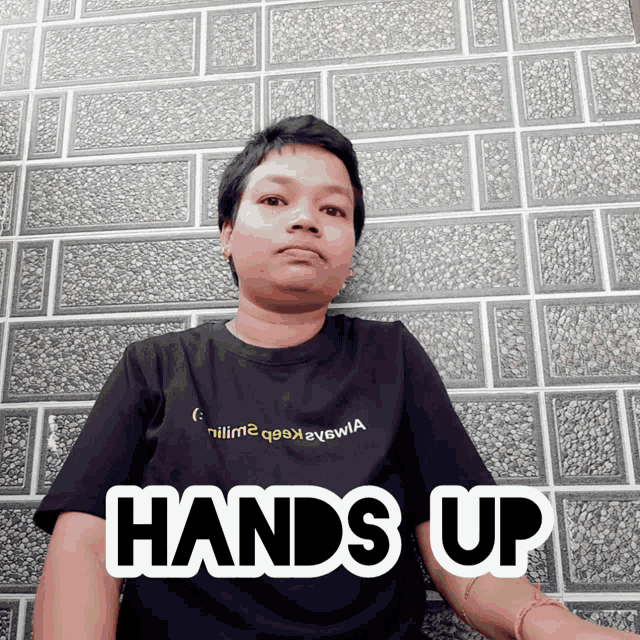 a man wearing a black shirt with the words hands up on it