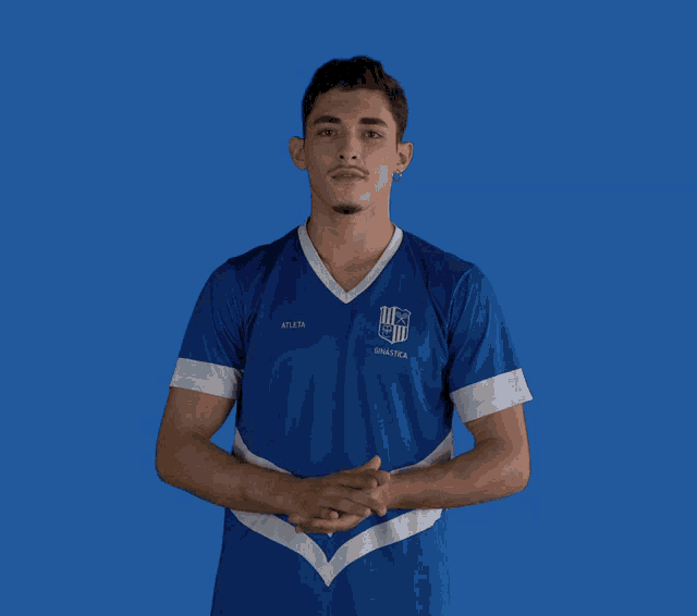 a young man wearing a blue shirt that says atleta