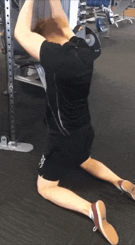 a man in a black shirt and shorts is kneeling down